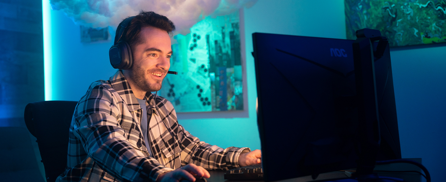 A man wearing A30 headset and playing on a computer